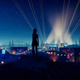 Zoe looks out over a concert at night in Road 96